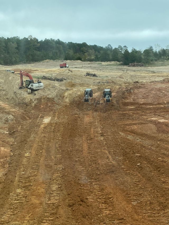 Excavator and dozers shaping a large pond site in East Texas