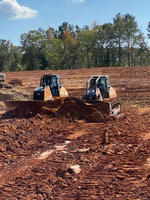 Two CASE dozers grading freshly cleared red dirt acreage