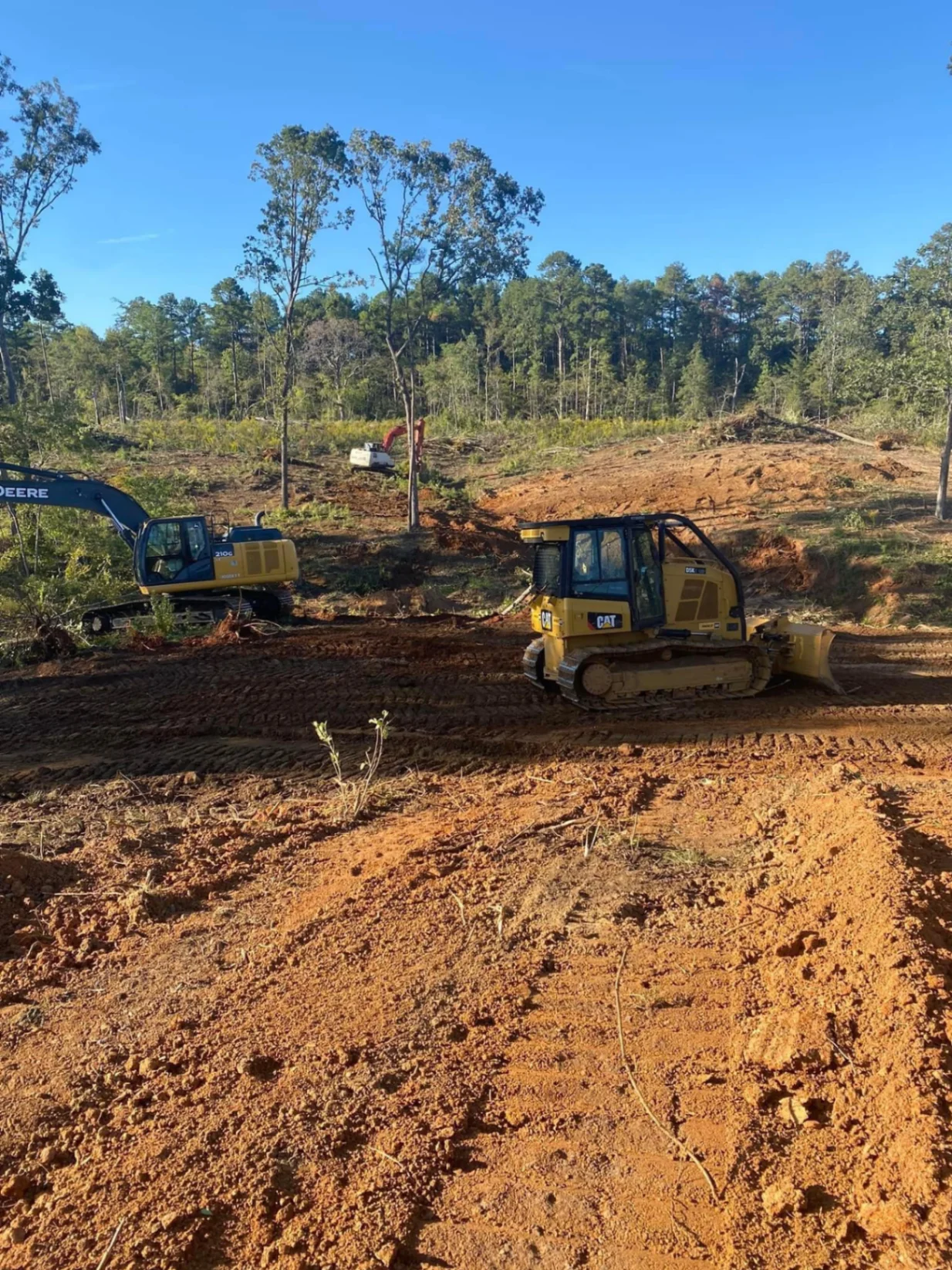John Deere excavator and CAT dozer preparing a building pad